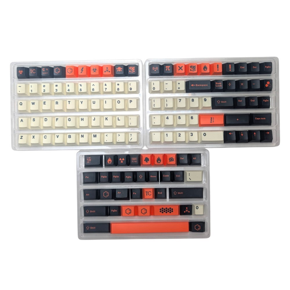 Three clear plastic trays containing custom mechanical keyboard keycaps arranged on a plain white background. The keycaps feature a color scheme of off-white, dark charcoal gray, and bright orange-red, with various symbols and macros printed on them.