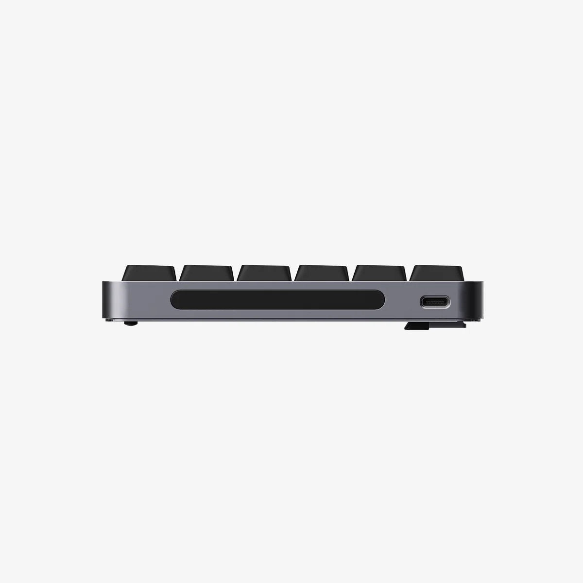 A close-up side view of a compact mechanical keyboard showing the side profile, keycaps, a horizontal slot, and a USB-C port, set against a solid white background.