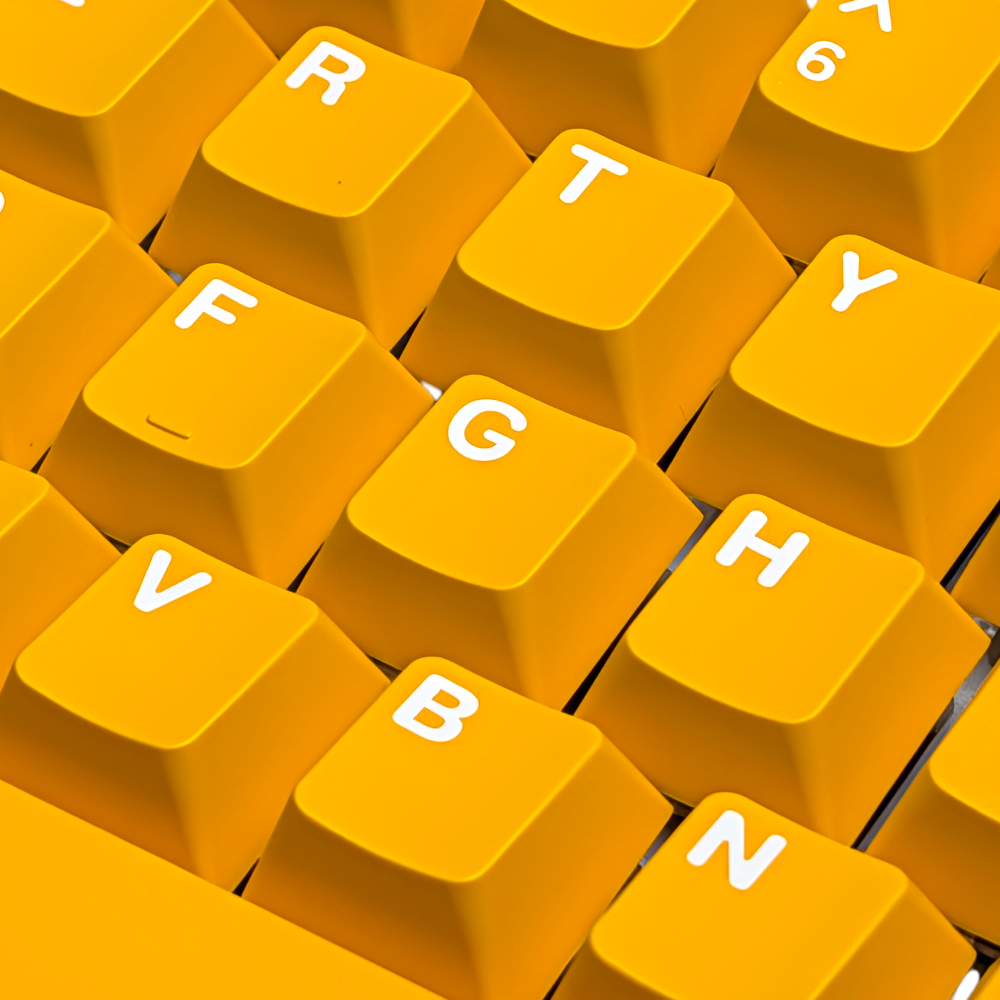 Overhead shot of durable ABS double-shot keycaps in Midas Touch Gold yellow colorway.