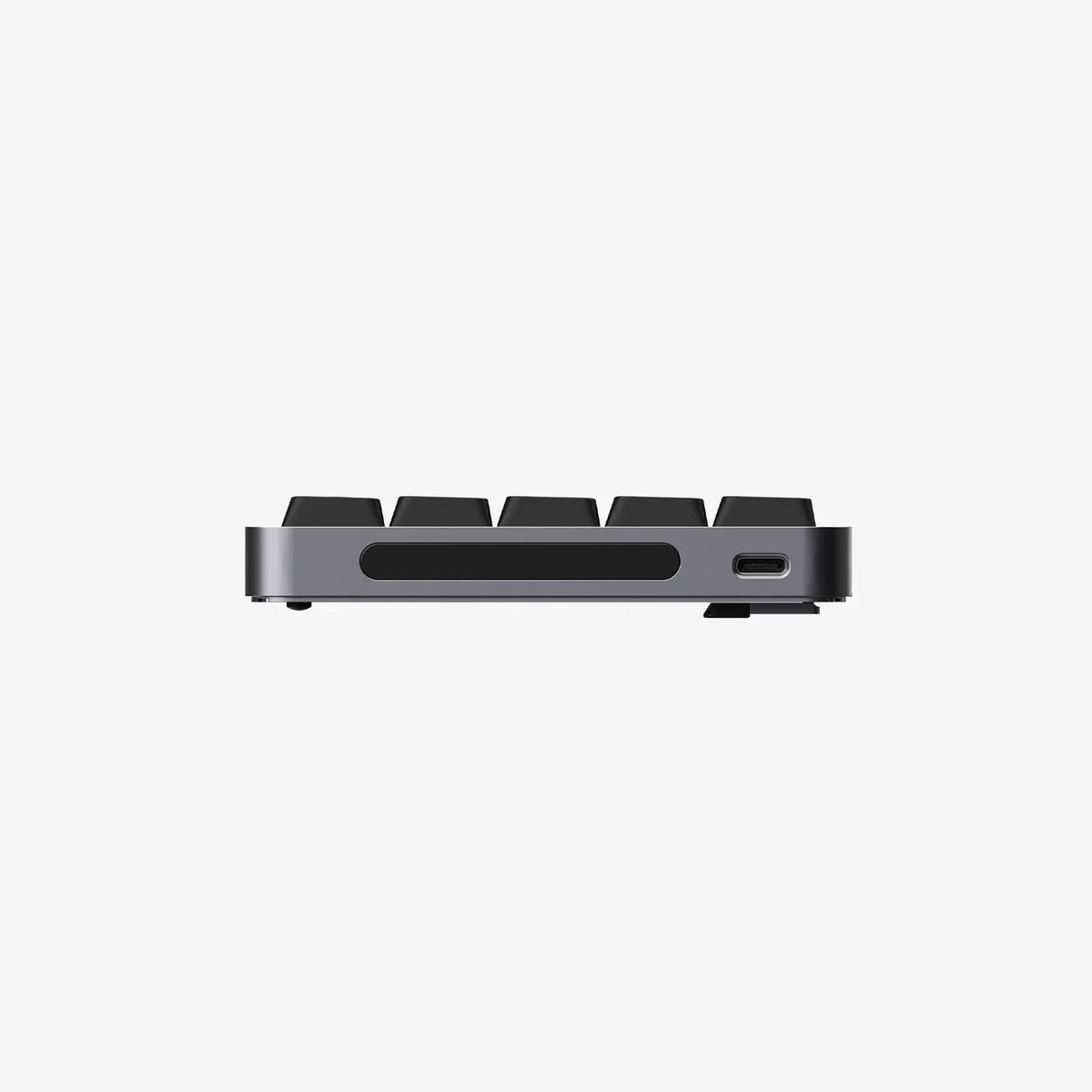 A close-up side view of a slim mechanical keyboard showing the side profile, keycaps, a horizontal cutout, and a USB-C port, set against a solid off-white background.