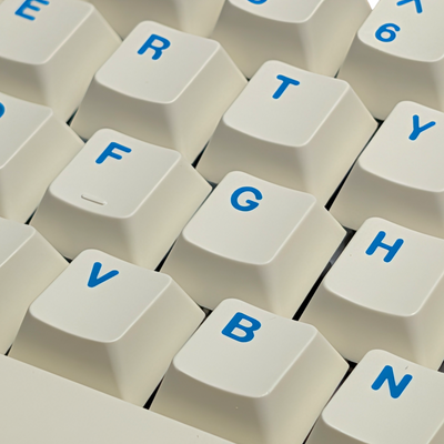 Macro shot highlighting the blue spacebar and shift keys with white legends and subtle pastel colors.