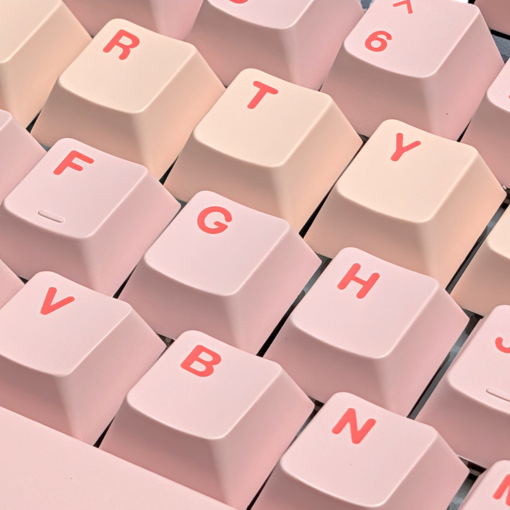 Angled perspective of the "Bubblegum Bliss" keycap set highlighting the texture and legends.