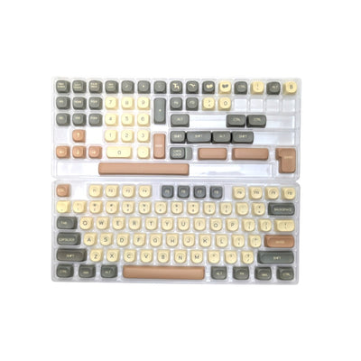 Top-down view of the 130-piece Hojicha Matcha Latte MOA profile PBT keycap set organized in plastic trays showing alphas, modifiers, and café novelty keys.