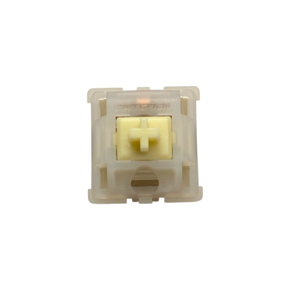Top-down macro view of Gateron Milky Yellow Pro heavy tactile switch showing yellow POM stem and translucent milky top housing.
