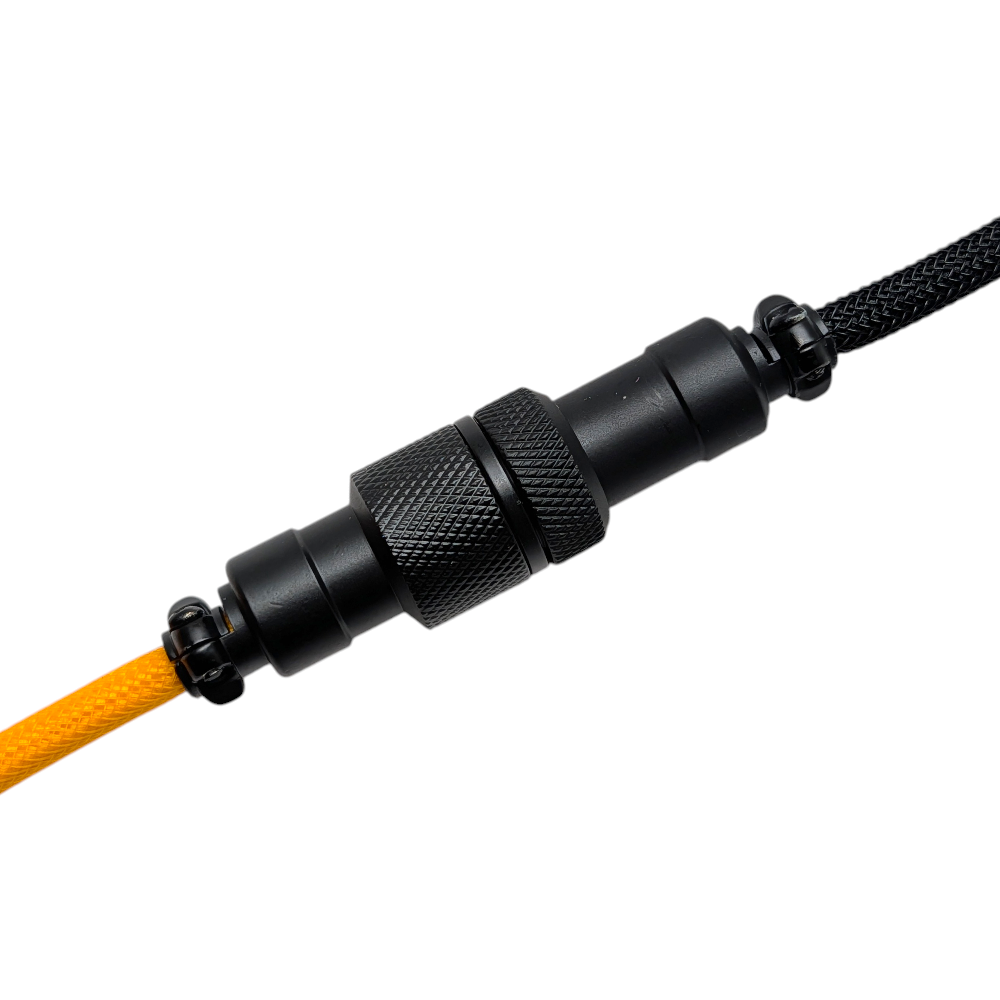 Top-down shot of the Onyx Orange aviator cable for custom keyboard builds, showing the matte black metal hardware and reinforced heatshrink.